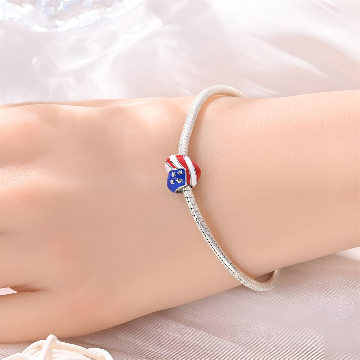 Bracelet argent avec charm cœur américain bleu, rouge et blanc, style moderne.