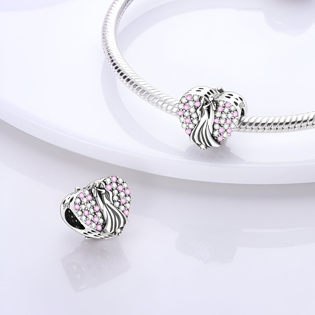Charm cœur argenté avec couple stylisé et détails roses, design élégant modèle Aino.