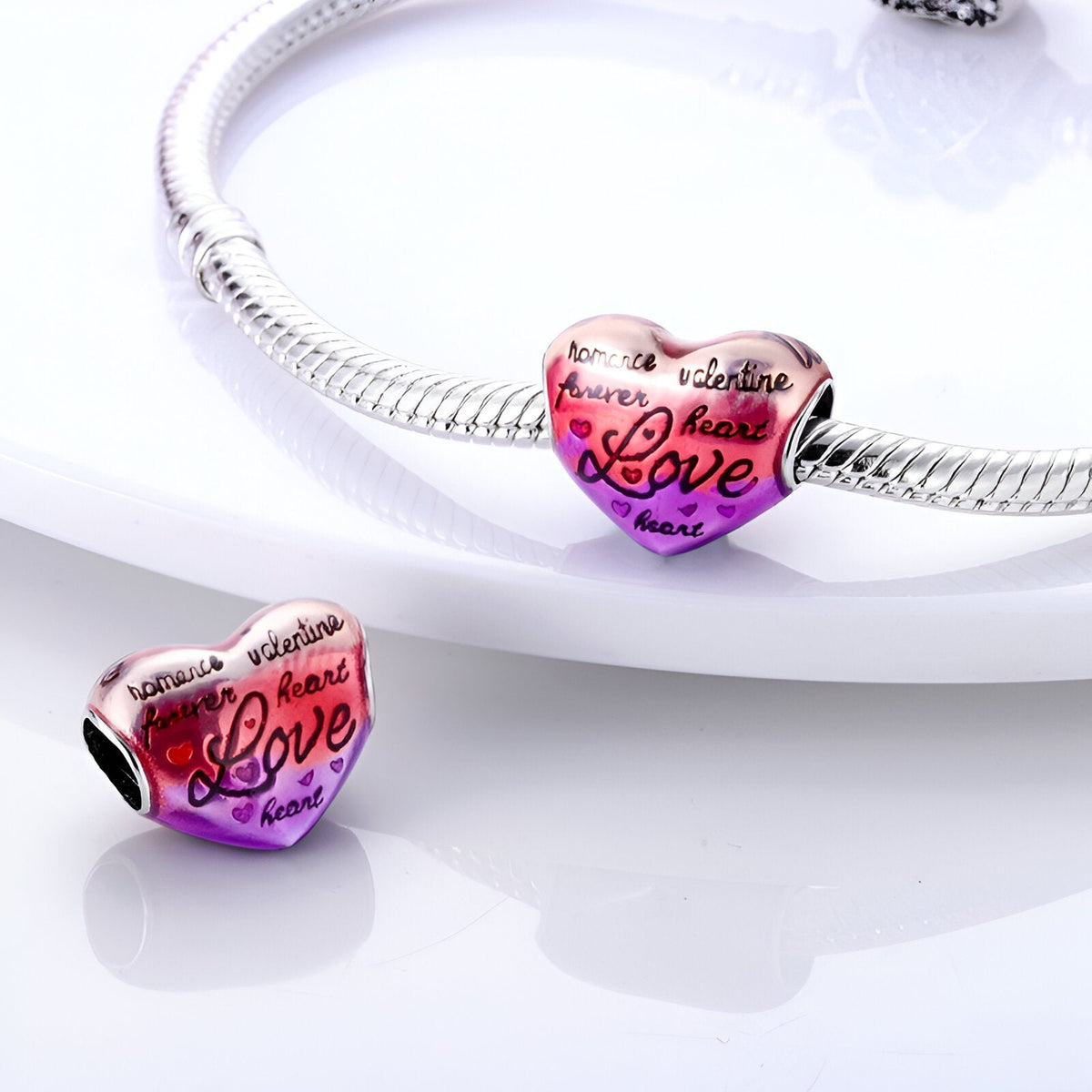 Charm cœur en métal rose dégradé gravé des mots "amour", "amitié", "love" design élégant et brillant.