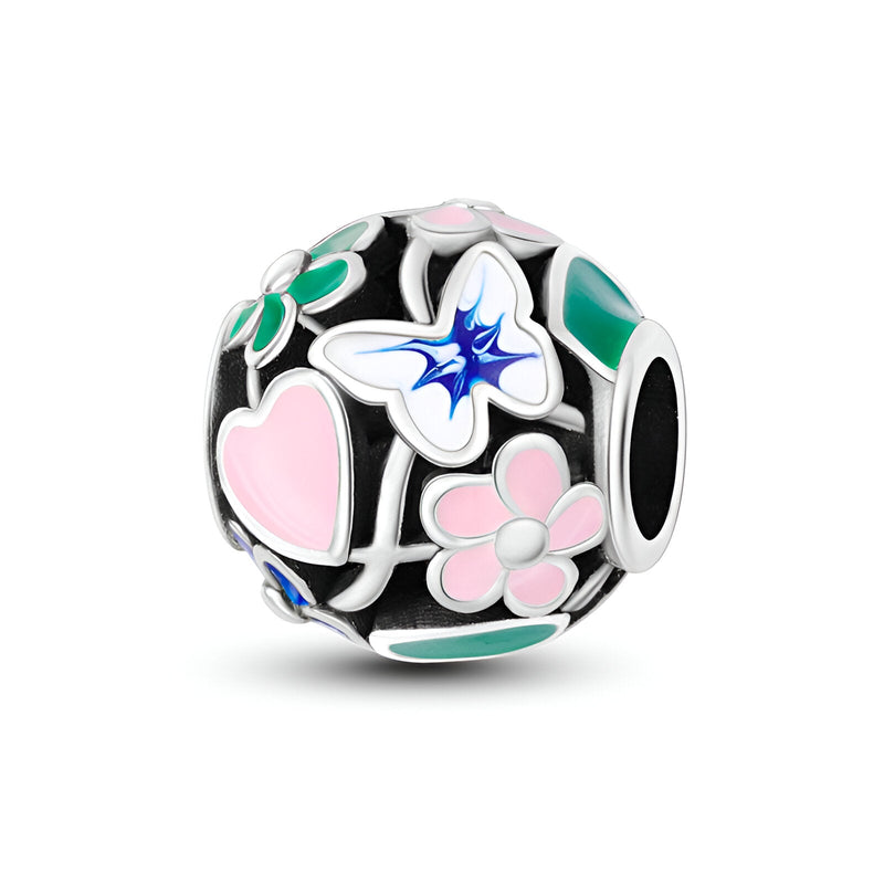 Charm rond en argent avec fleurs colorées et papillon bleu détaillé.