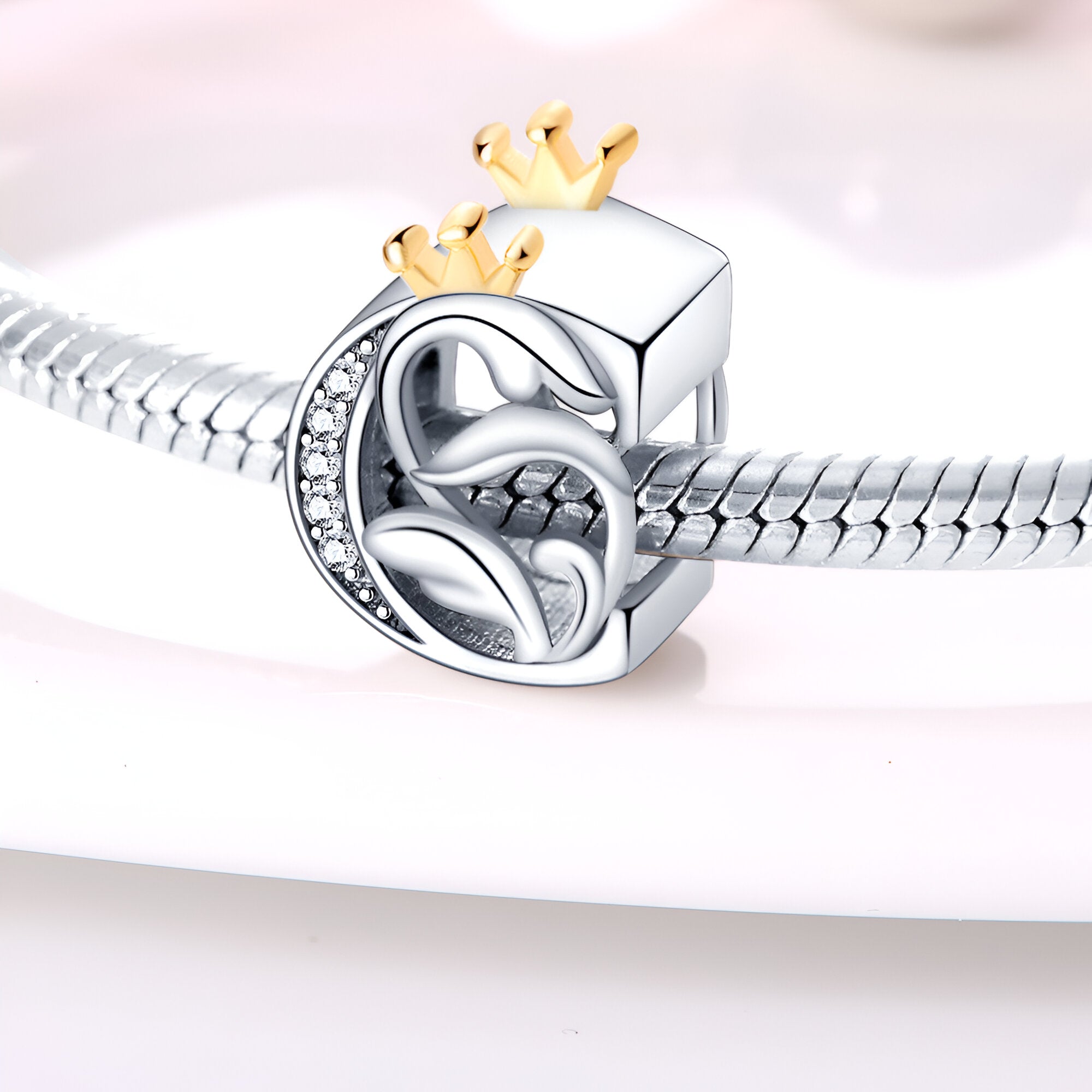 Charm lettre C en argent avec couronne dorée et petits cristaux sertis, design élégant et moderne.