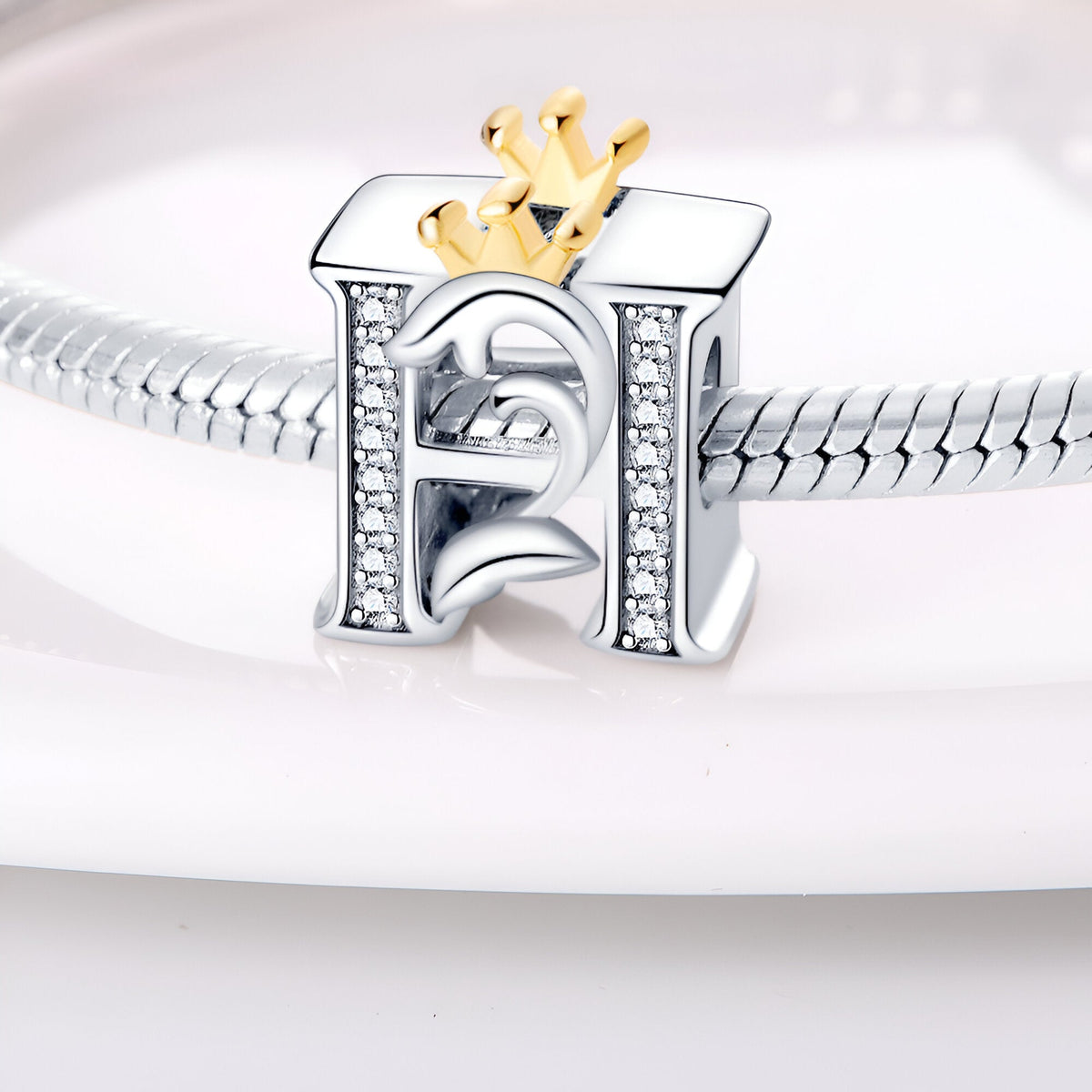 Charm lettre H en argent orné de pierres blanches avec couronne dorée, modèle Hania.
