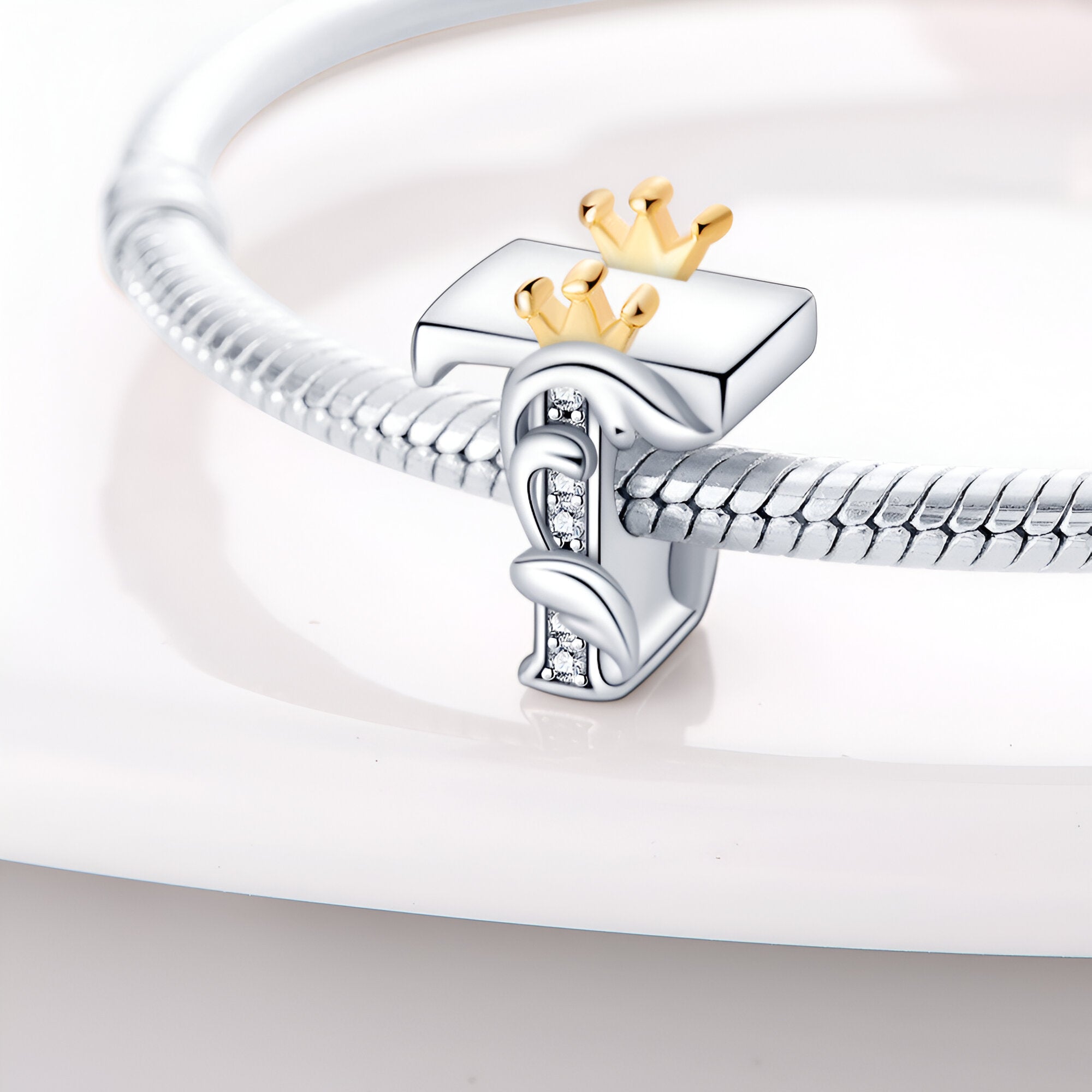 Charm lettre T en argent avec couronne dorée, style élégant et fin détail décoratif.