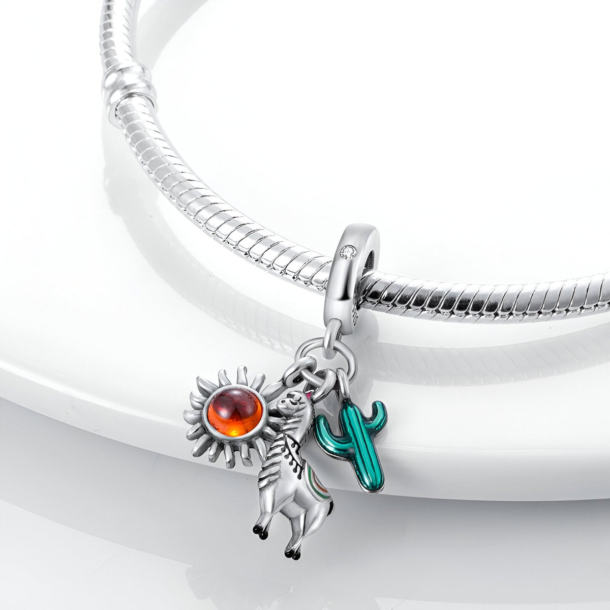 Bracelet argenté avec pendentifs alpagas, soleil orange et cactus vert émaillé.