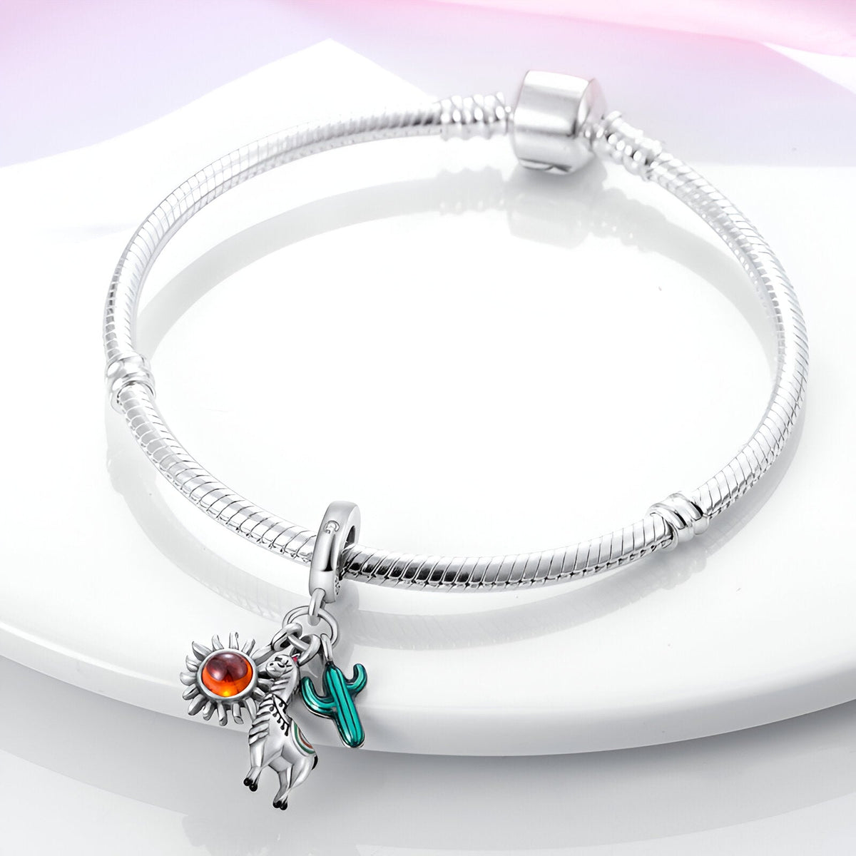 Bracelet argenté avec pendentif alpaga noir et blanc, soleil argenté et cactus vert émaillé.