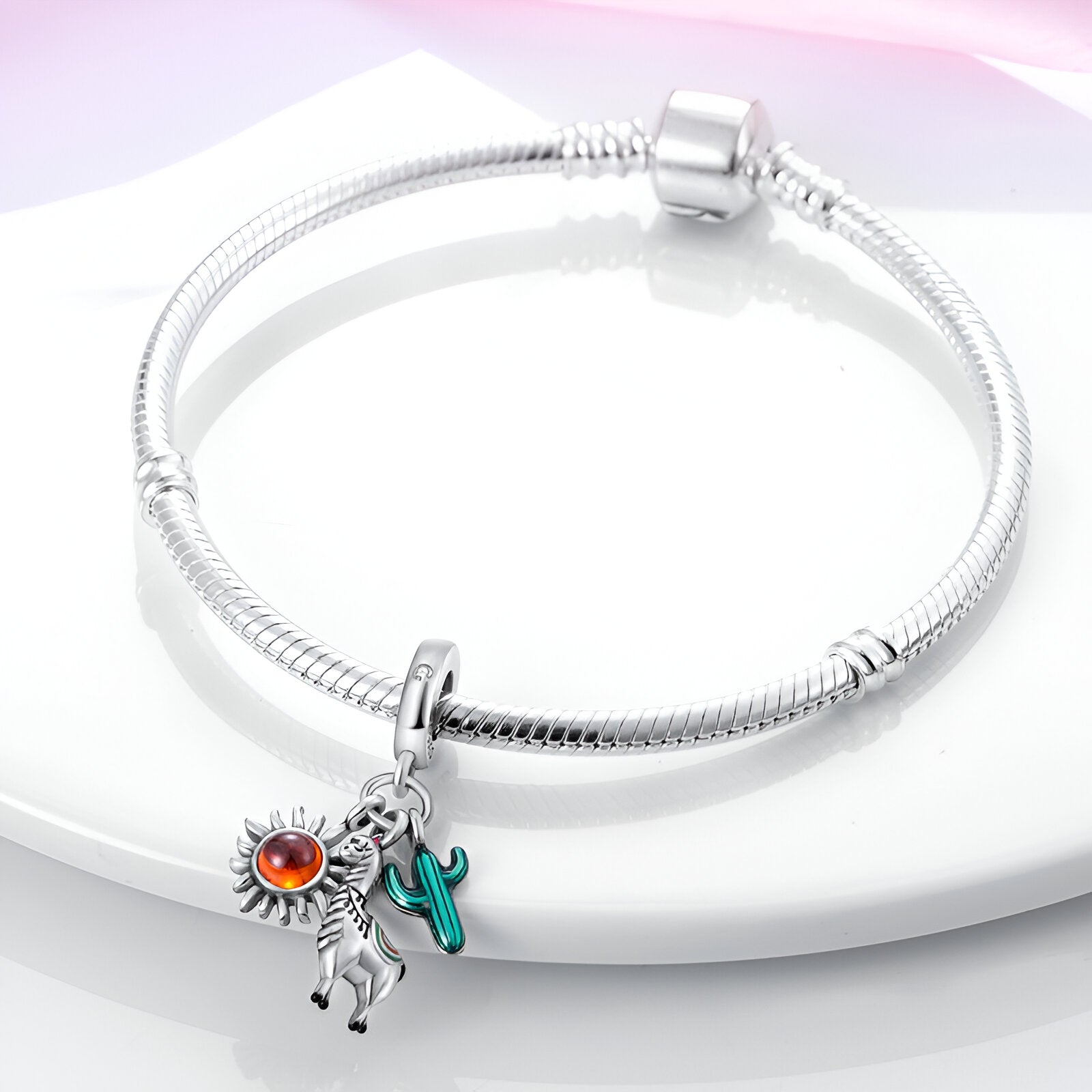 Bracelet argenté avec pendentif alpaga noir et blanc, soleil argenté et cactus vert émaillé.