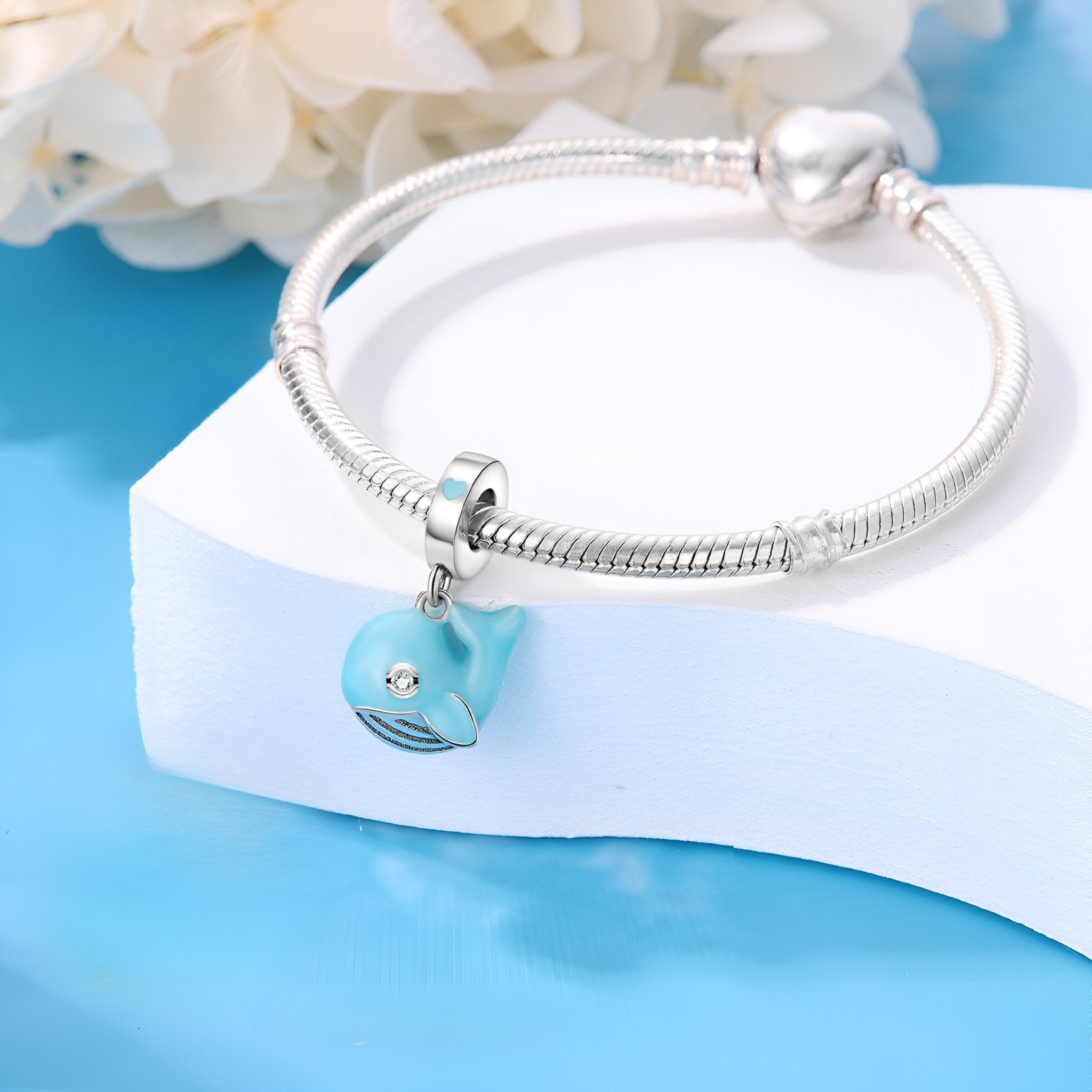 Breloque baleine bleue en émail sur bracelet argenté à maillons serpent.