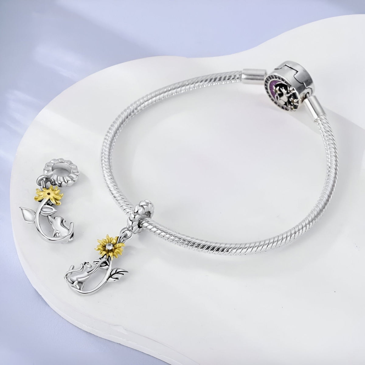 Bracelet argenté avec pendentif chat et tournesol jaune en métal brillant.