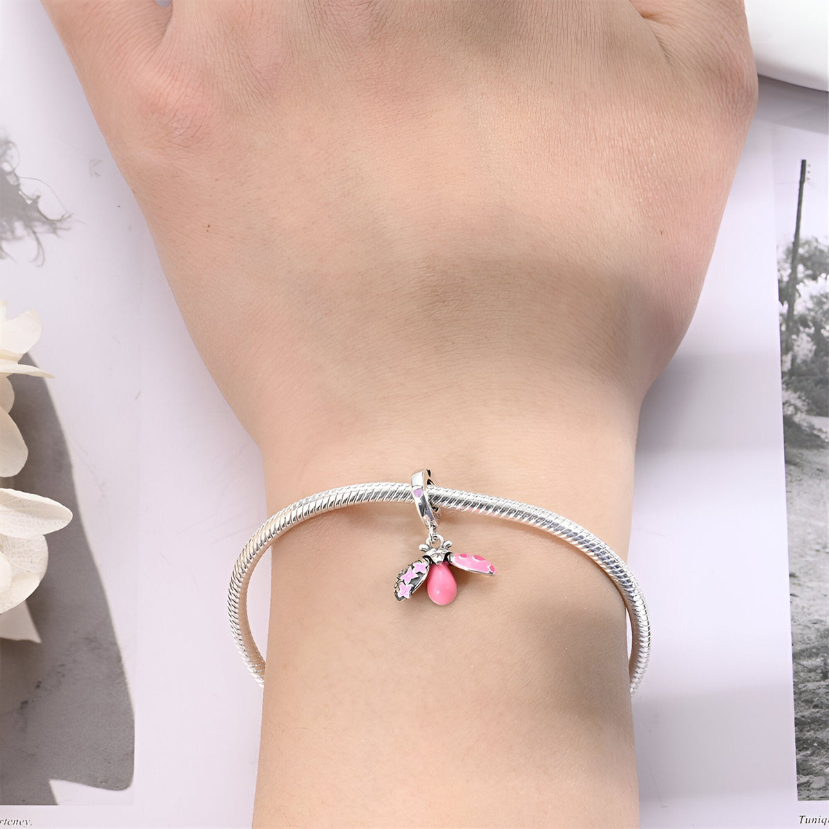 Bracelet argenté avec pendentif coccinelle rose et cristal éclatant.