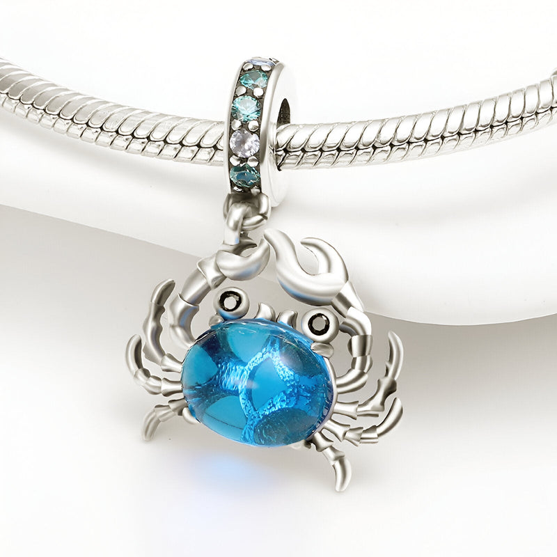 Charm pendentif crabe argent avec pierre bleue facettée et oxydes turquoise sur anneau.