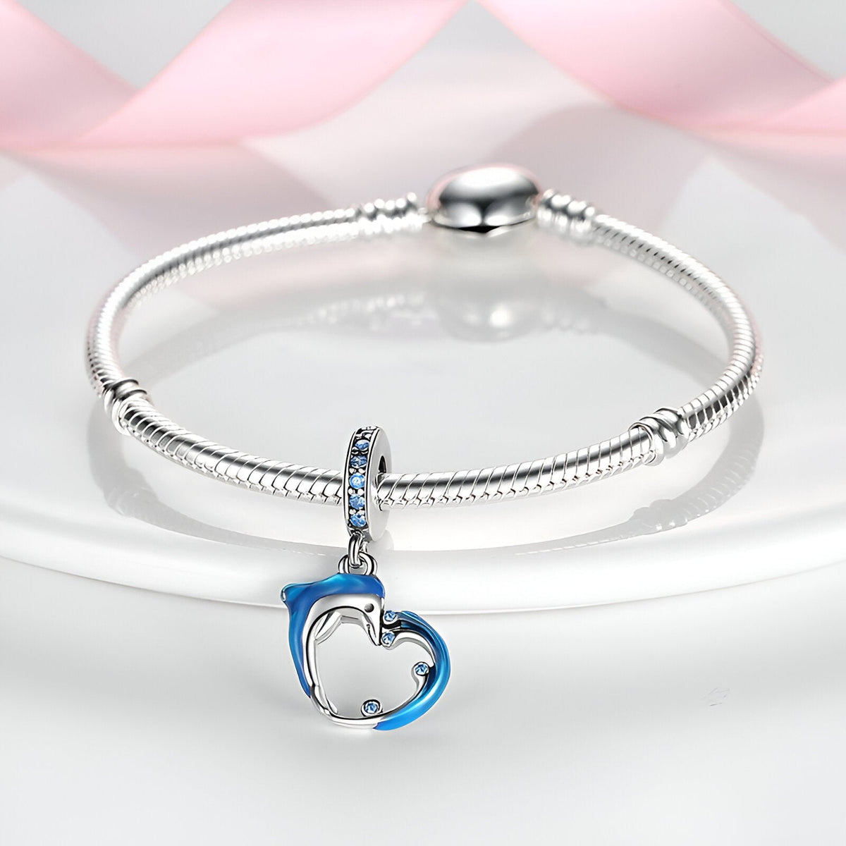 Charm pendentif dauphin bleu et vague argentée sur bracelet serpent argenté.