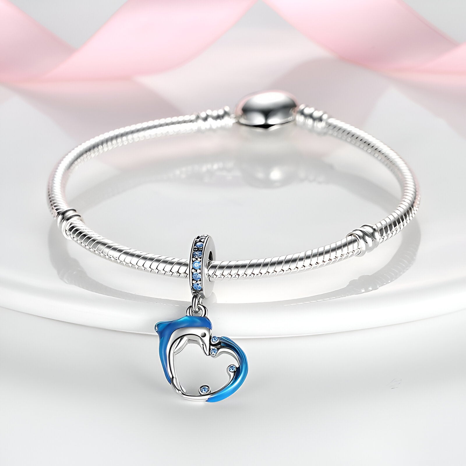 Charm pendentif dauphin bleu et vague argentée sur bracelet serpent argenté.