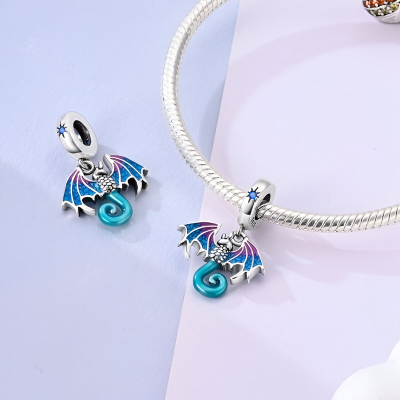 Charm pendentif dragon bleu en émail avec ailes violettes sur chaîne serpent argentée.