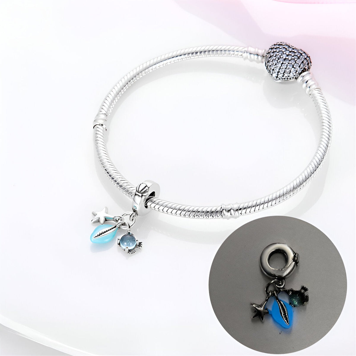 Bracelet argenté serpent avec pendentifs coquillage bleu et étoile de mer noire.
