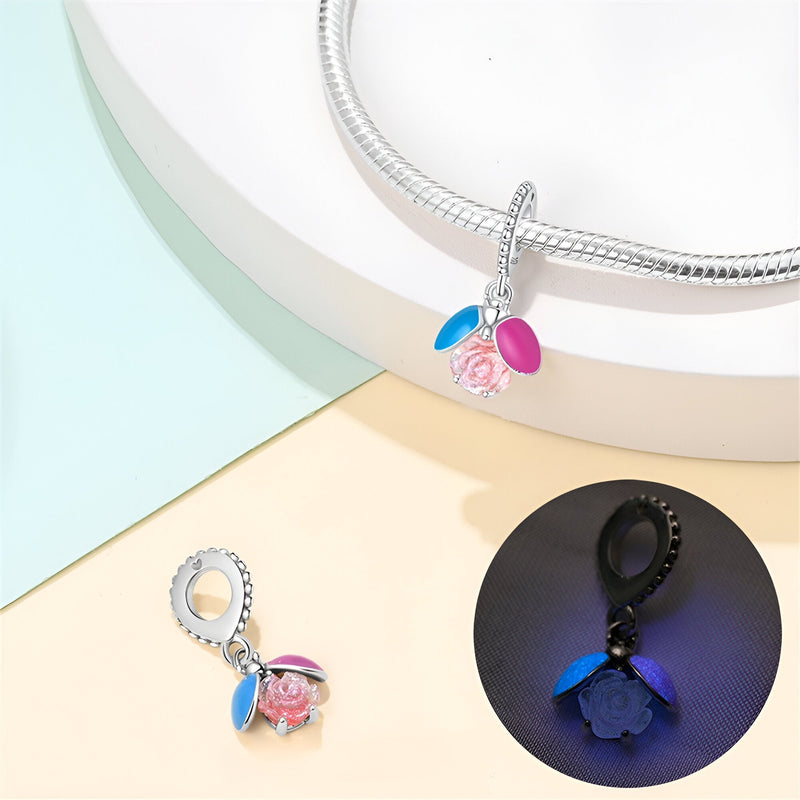 Charm pendentif en argent avec luciole rose scintillante et petites ailes bleu et fuchsia.