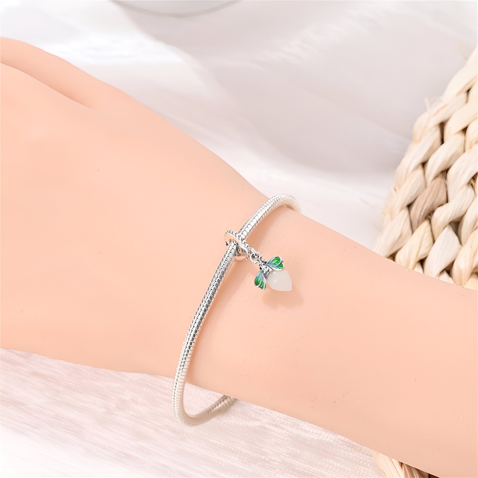 Charm pendentif luciole translucide en argent, détail vert, porté sur bracelet fin argenté.