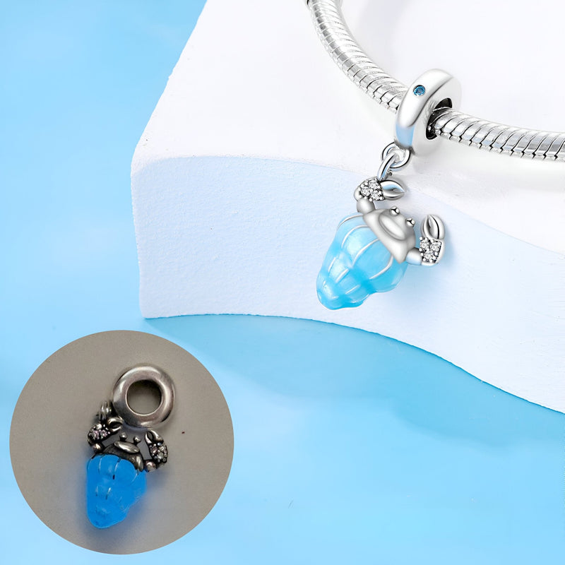 Pendentif charme pagure bleu en argent avec coquillage turquoise scintillant.