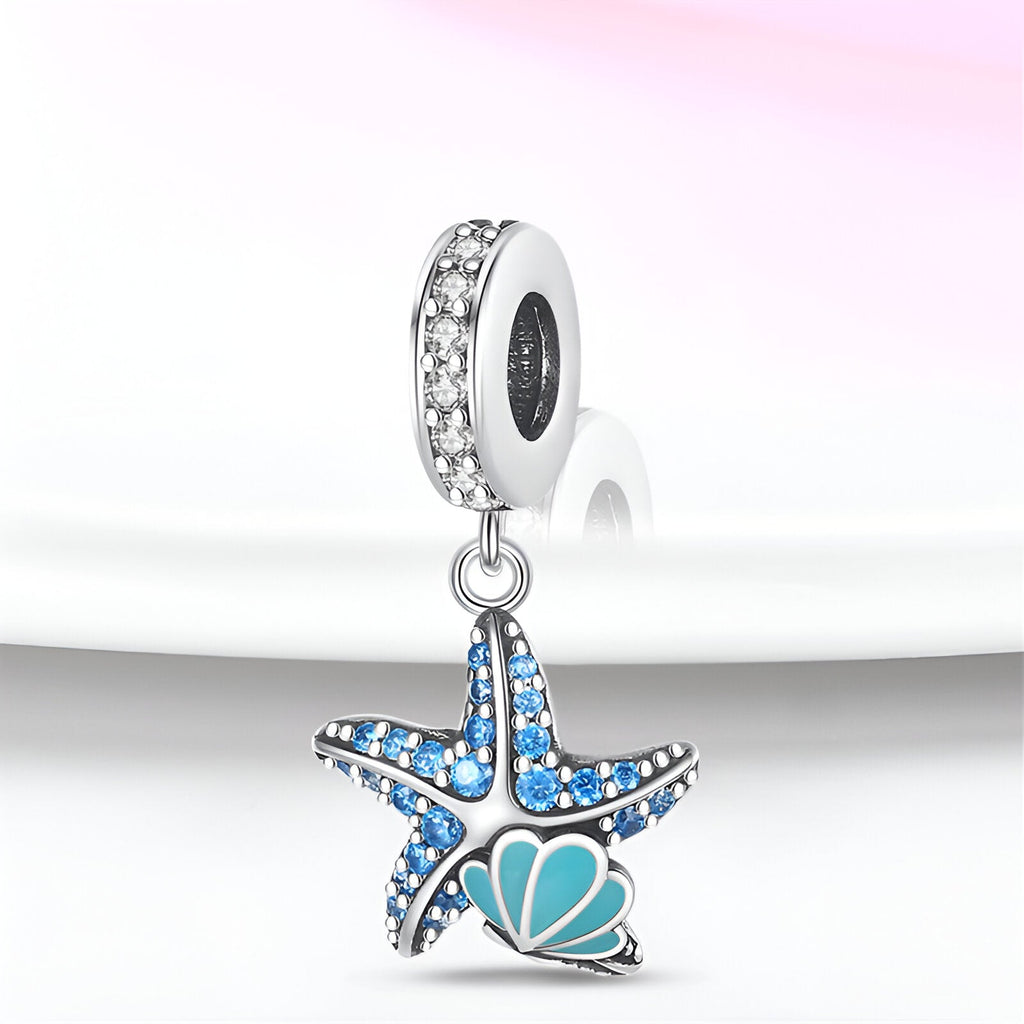 Charm pendentif étoile de mer bleue et argentée avec coquillage turquoise et anneau strassé.