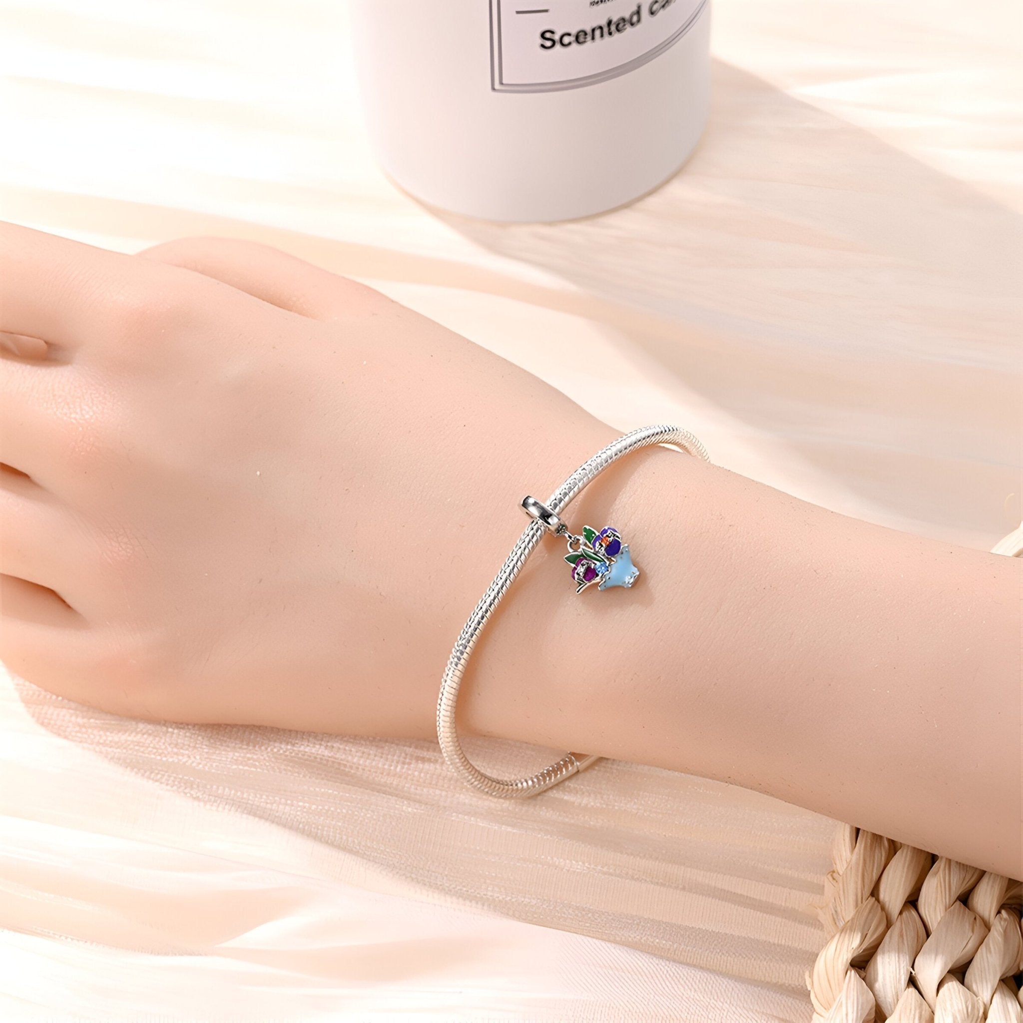 Bracelet argenté fin avec pendentif fleur de pensée colorée bleu et violet.