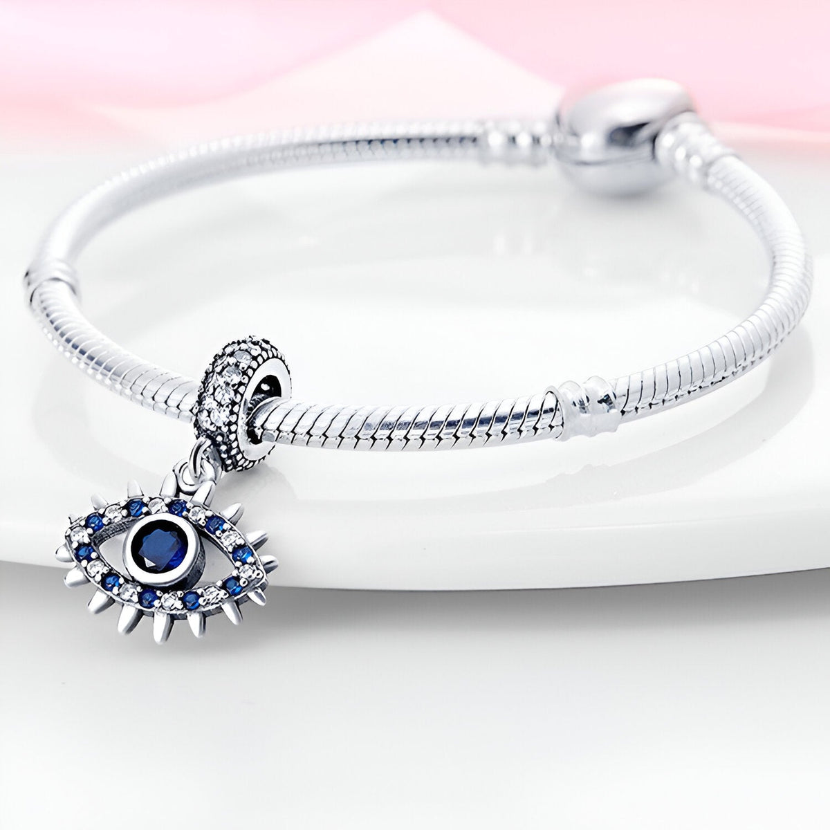 Bracelet argent avec pendentif oeil de protection bleu orné de petits cristaux blancs et bleus.