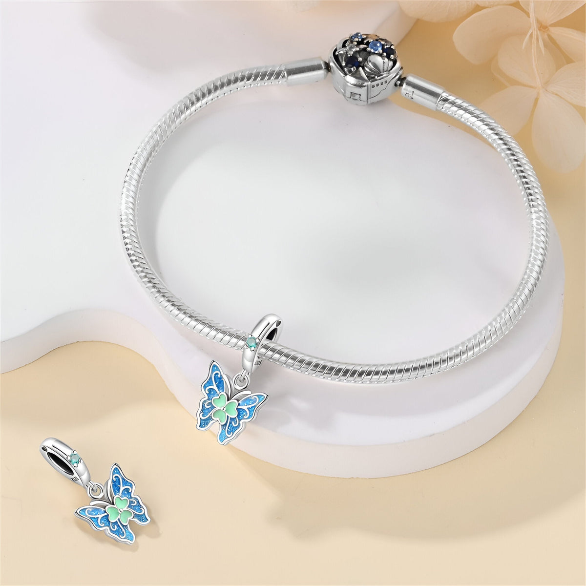 Bracelet argenté avec pendentif papillon bleu et vert, style délicat et élégant.
