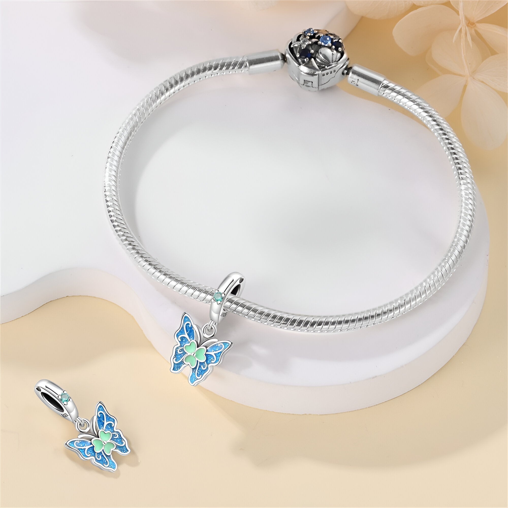 Bracelet argenté avec pendentif papillon bleu et vert, style délicat et élégant.