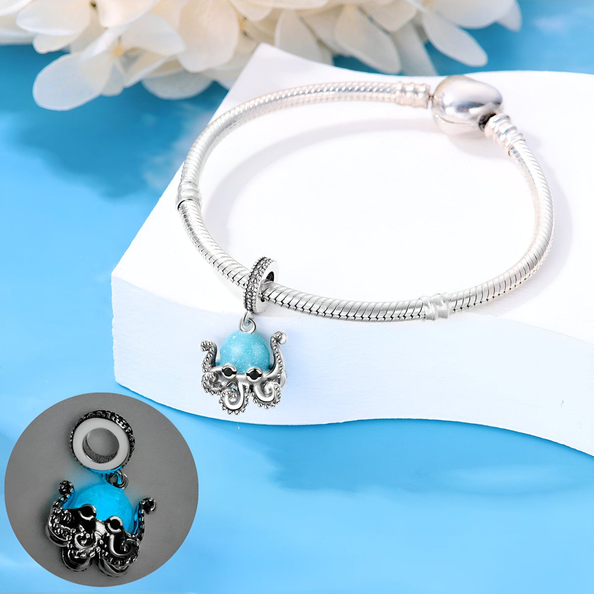 Charm pendentif pieuvre bleue en métal argenté avec détails délicats sur bracelet serpent argenté.