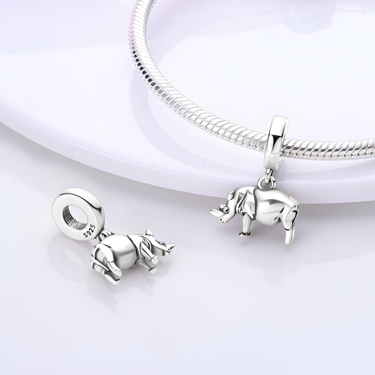 Pendentif charm rhinocéros en argent brillant, détail réaliste, finition lisse, monté sur bracelet serpent.