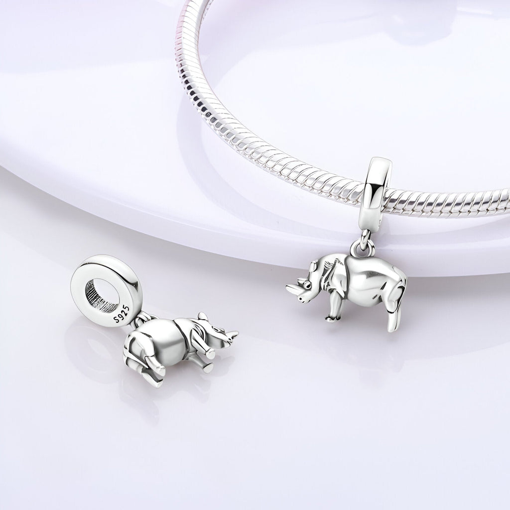 Pendentif charm rhinocéros en argent brillant, détail réaliste, finition lisse, monté sur bracelet serpent.