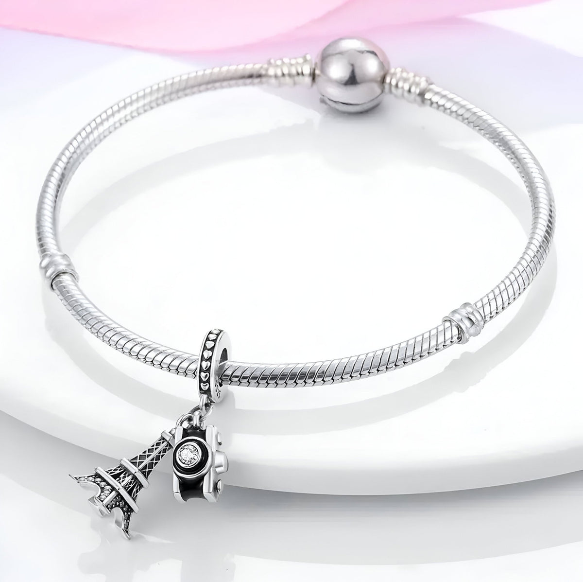 Bracelet argenté avec pendentifs Tour Eiffel et appareil photo détaillés.