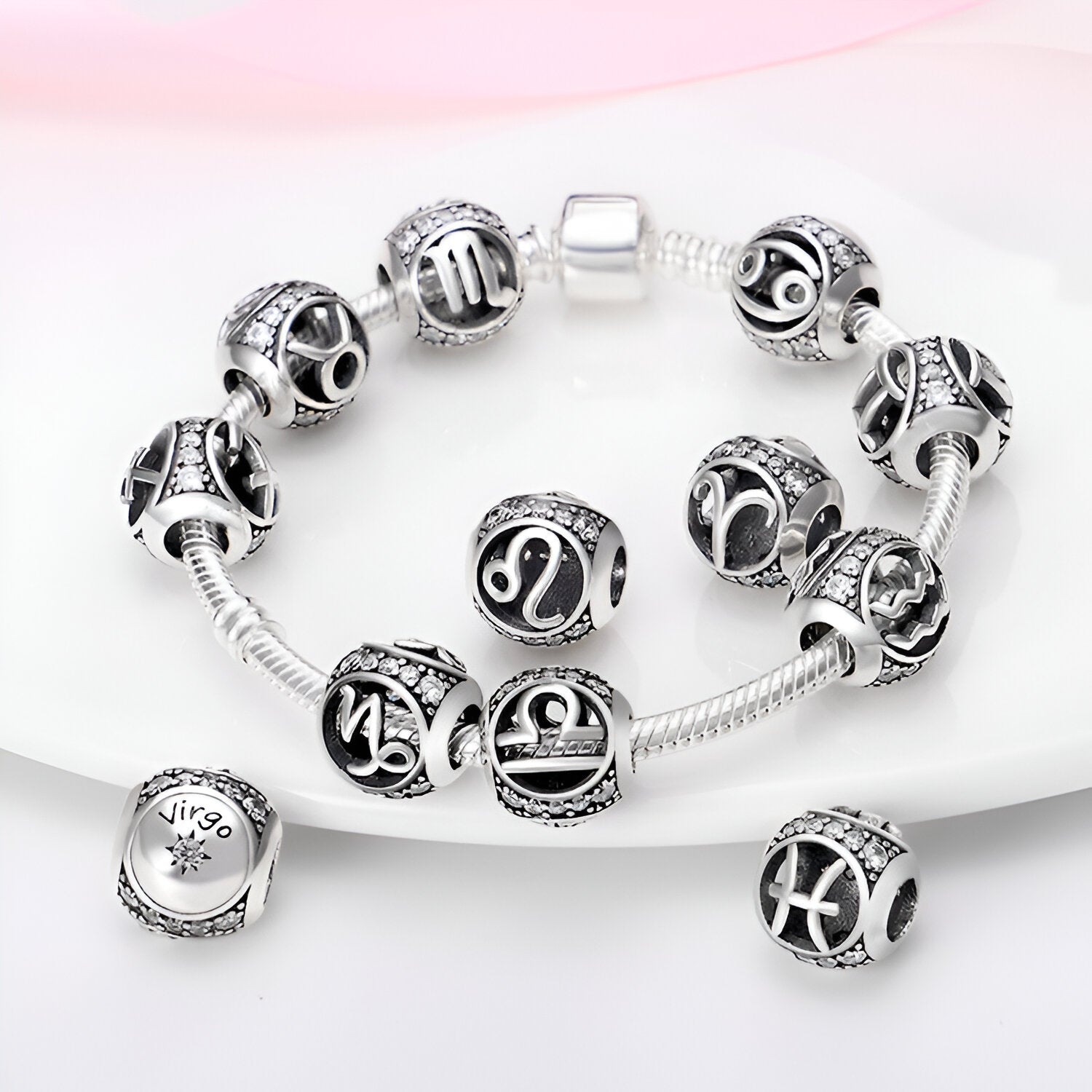 Bracelet argent avec charms ronds noirs à symboles zodiacaux sculptés, style Siana.
