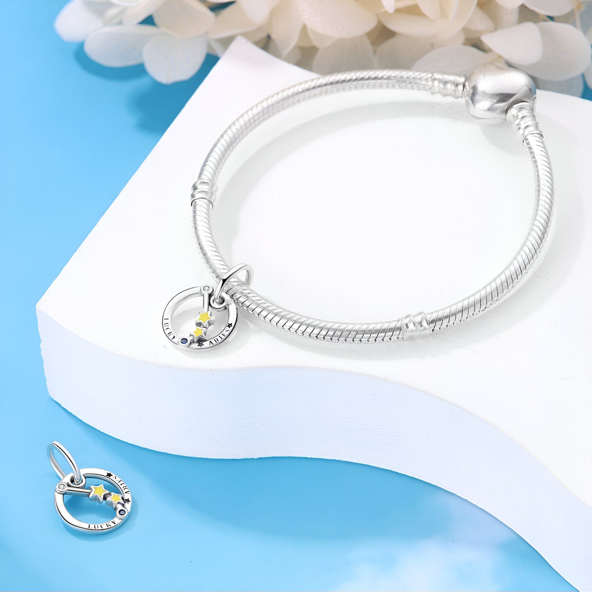 Bracelet argenté avec charms signe zodiacal Bélier orné d’étoiles jaunes et blanches.