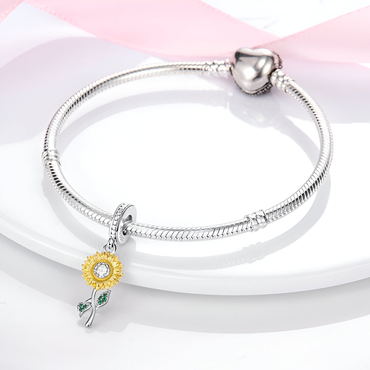 Bracelet argenté avec pendentif tournesol jaune et détails verts sur tige délicate.