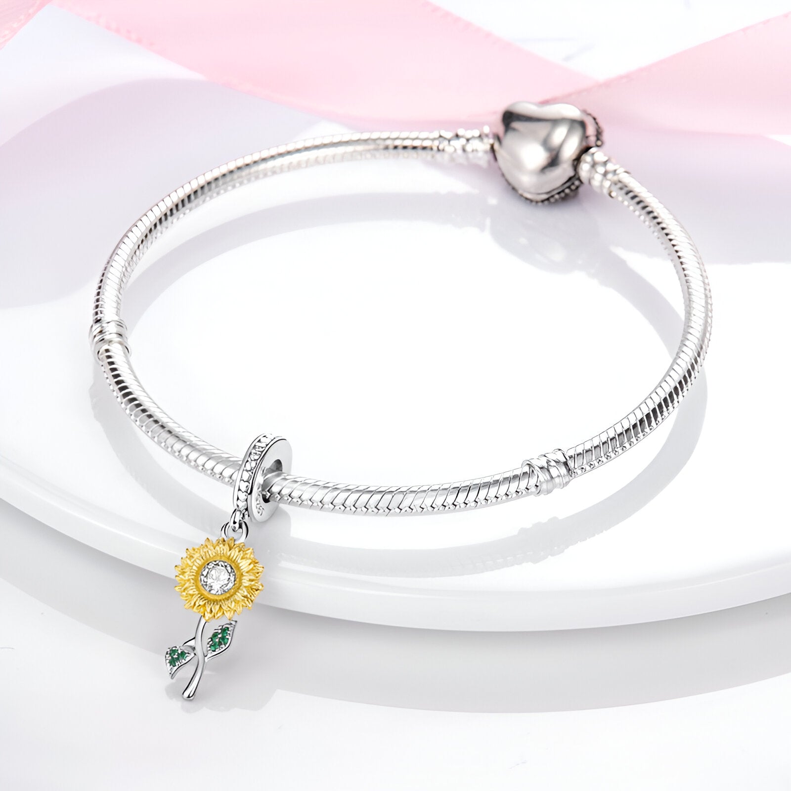 Bracelet argenté avec pendentif tournesol jaune et détails verts sur tige délicate.