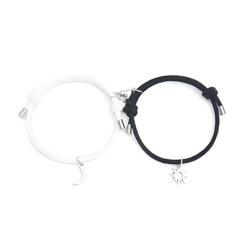 Duo de bracelets cordon blanc et noir avec pendentifs lune et soleil argentés, fermoirs réglables.