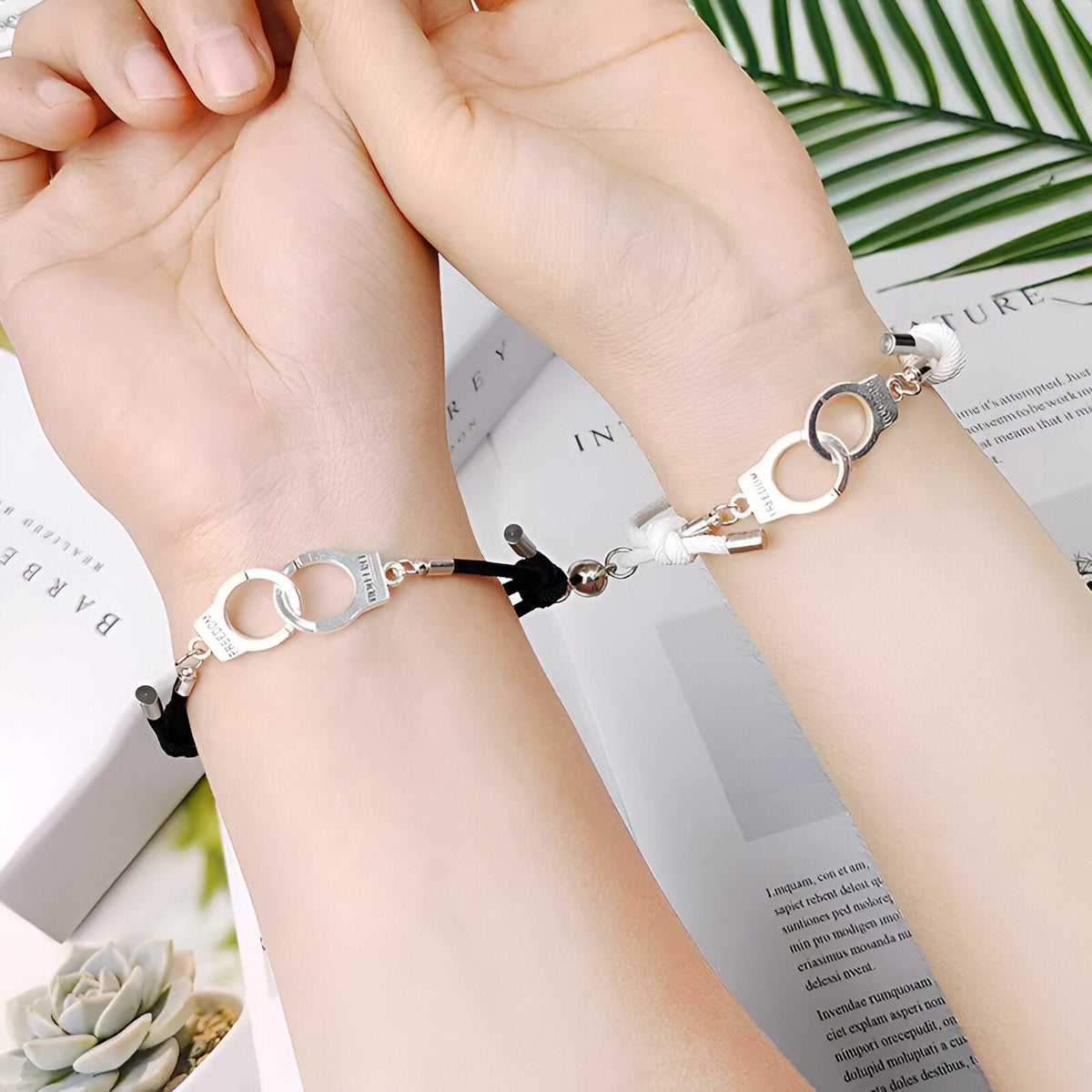 Duo de bracelets cordon noir avec menottes argentées, design couple unisexe élégant.