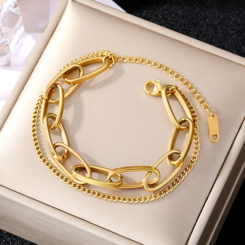 Duo de bracelets en acier inoxydable doré, un modèle chaîne épaisse et une chaîne fine élégante.