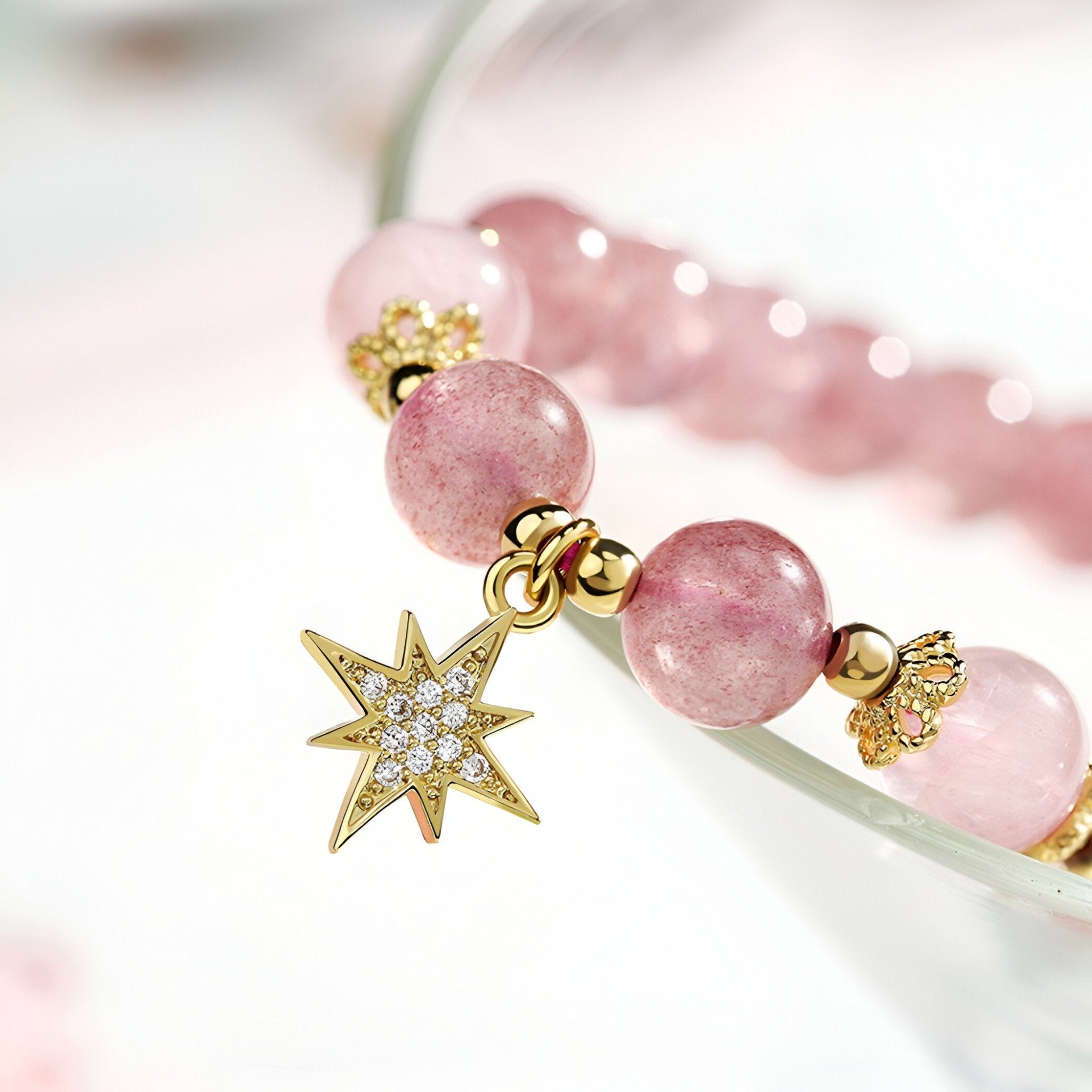 Duo de bracelets roses en pierres de cristal avec pendentifs étoile et lune dorés sertis de cristaux brillants.