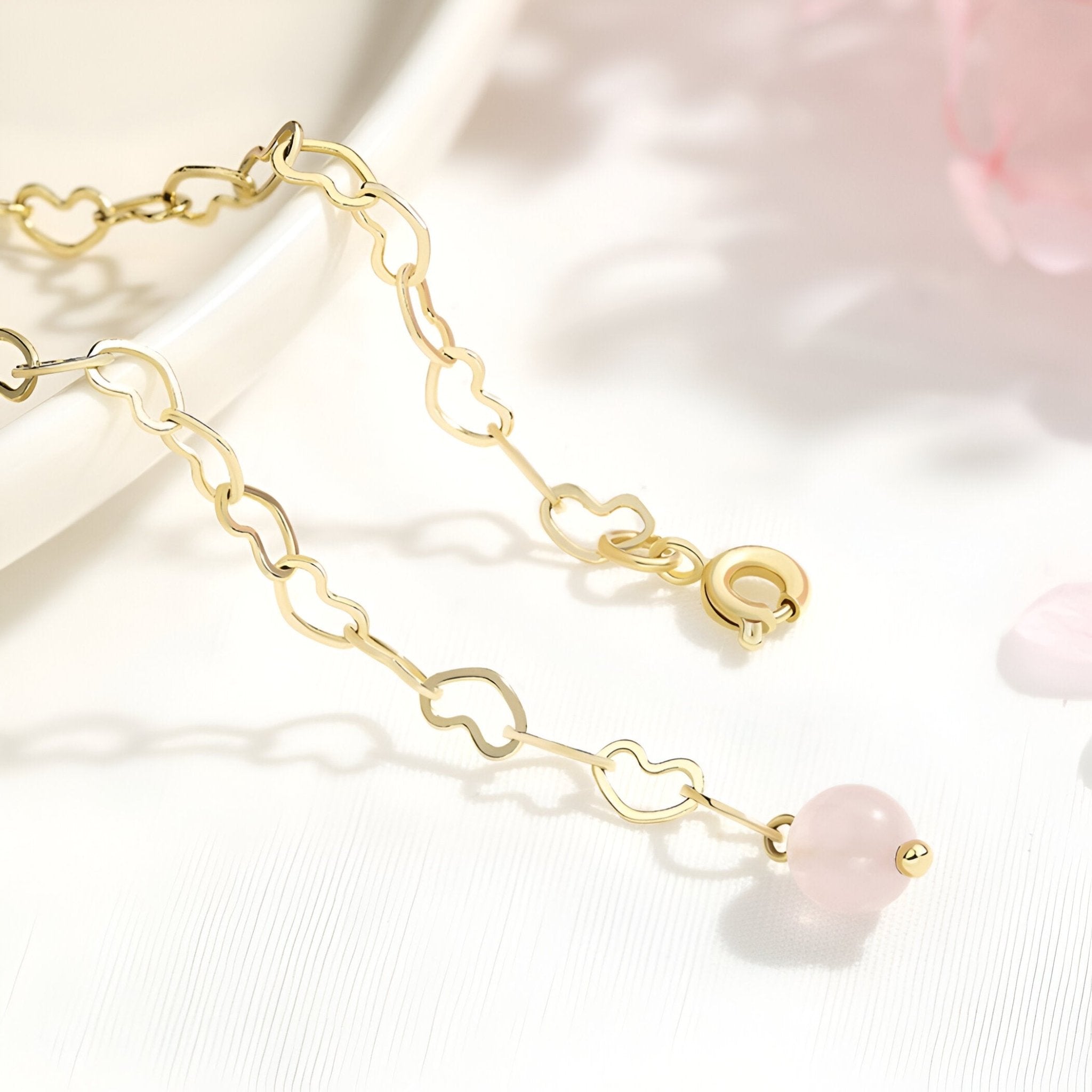 Duo de bracelets dorés avec pierres de cristal rose, détails étoile et lune, style délicat.