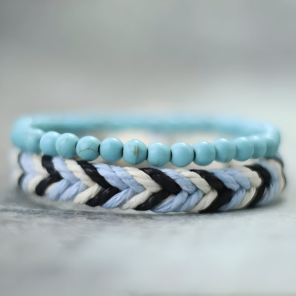 Un bracelet perles turquoises bleu clair et un bracelet corde tressée bleu, blanc et noir.