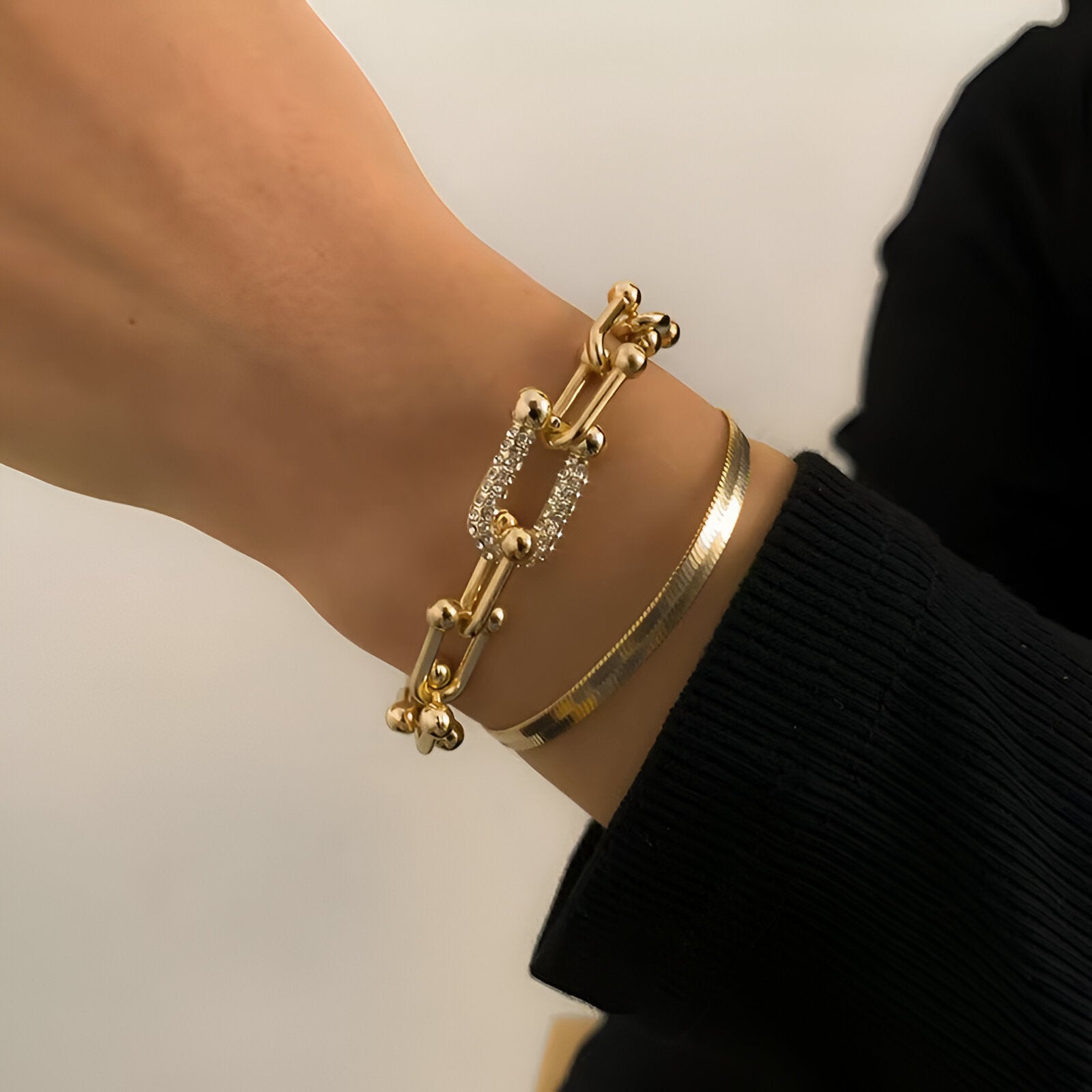 Duo de bracelets mousqueton en acier inoxydable doré, design élégant et moderne, pour femme.