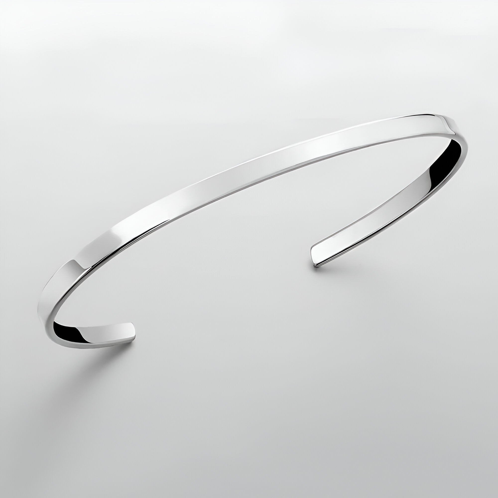Bracelet jonc fin en acier inoxydable argenté avec finition polie et bords biseautés.