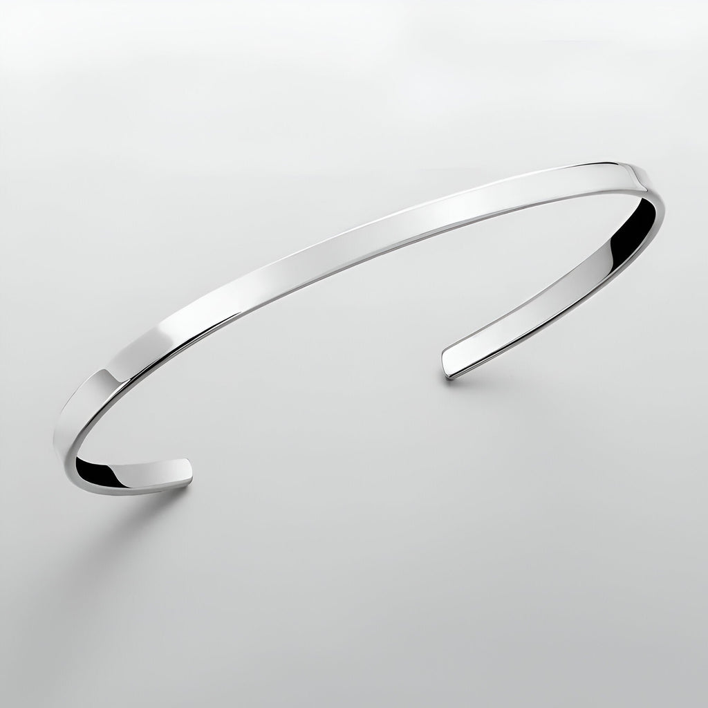 Bracelet jonc fin en acier inoxydable argenté avec finition polie et bords biseautés.