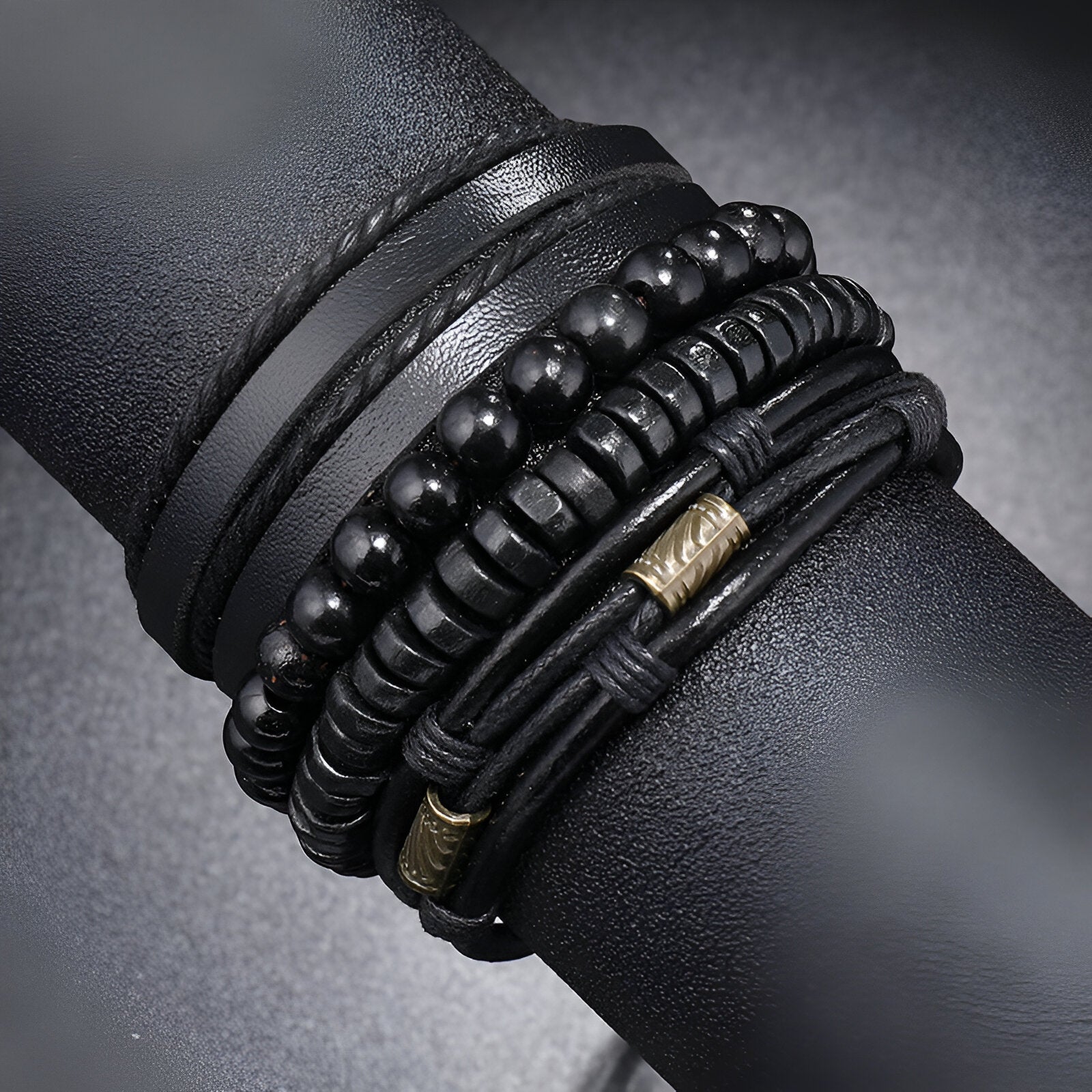 Ensemble de 4 bracelets noirs en microfibre et perles de bois avec détails métalliques dorés, style élégant mixte.