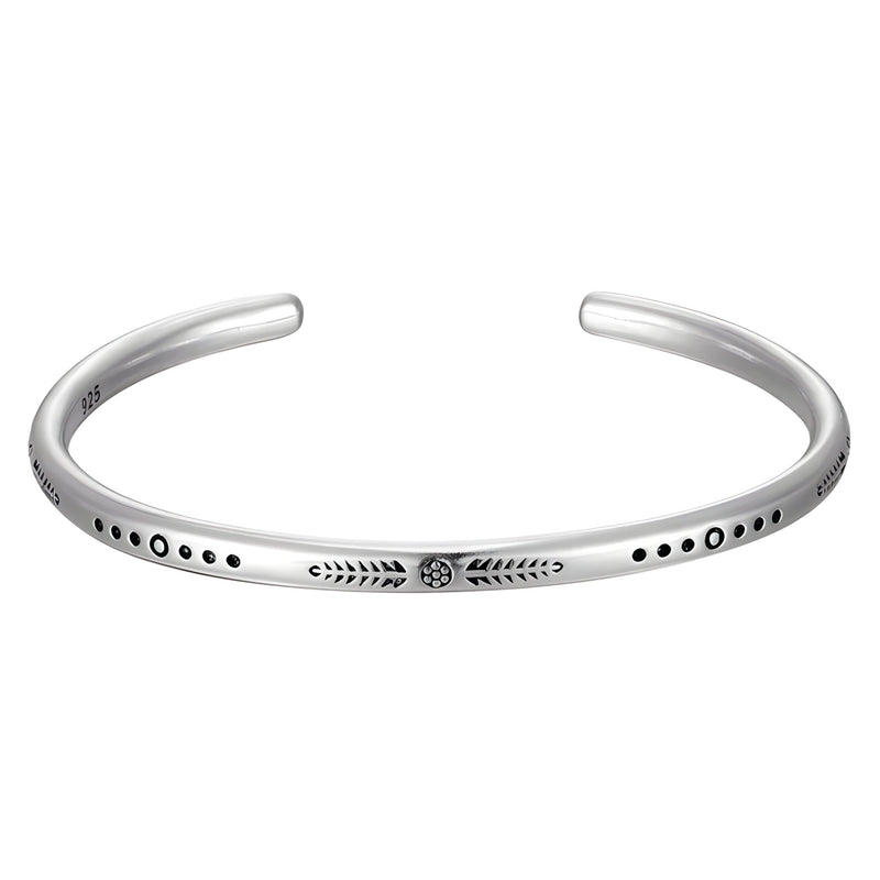 Bracelet manchette tibétain en argent gris avec gravures et motifs ronds noirs.