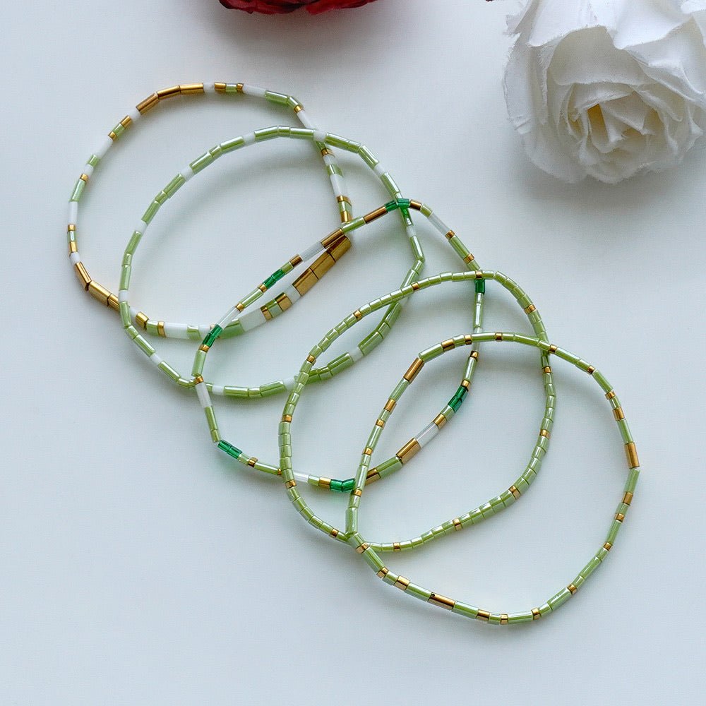 Ensemble de cinq bracelets élastiques en perles du Japon Tila, vert céladon, blanc lumineux, détails dorés, modèle Piya