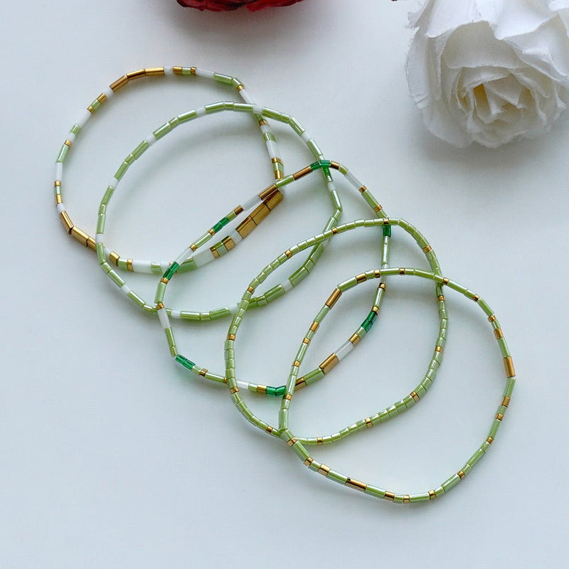Ensemble de cinq bracelets élastiques en perles du Japon Tila, vert céladon, blanc lumineux, détails dorés, modèle Piya