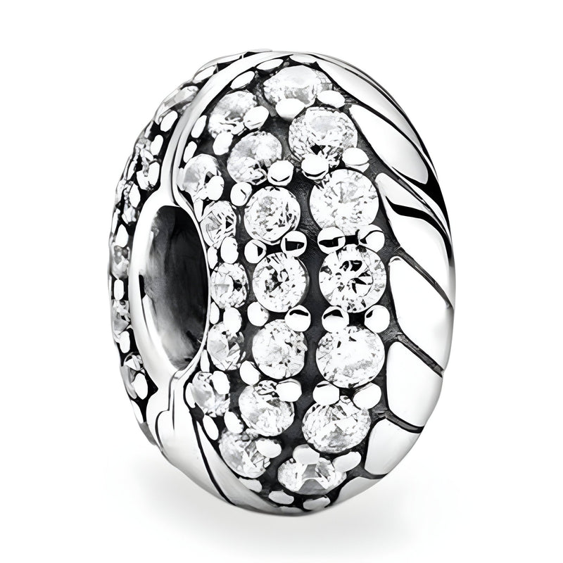 Espaceur rond en argent orné de rangées de cristaux brillants et détails gravés en relief.