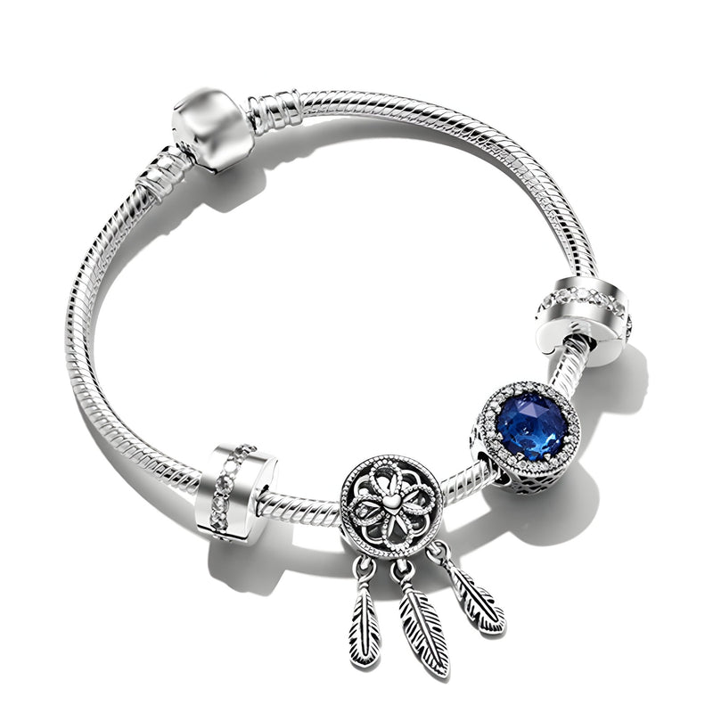 Bracelet argenté avec espaceurs et pendentif attrape-rêves orné d'un zircon bleu rond.