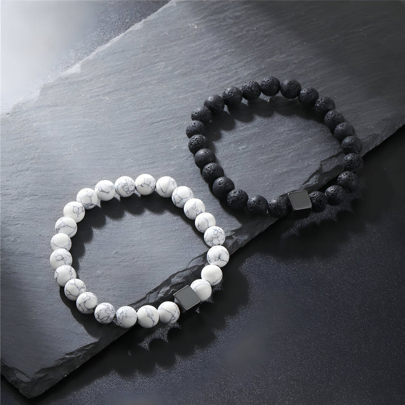 Paire de bracelets élastiques en pierres volcaniques, un noir mat, un blanc marbré gris, style homme.